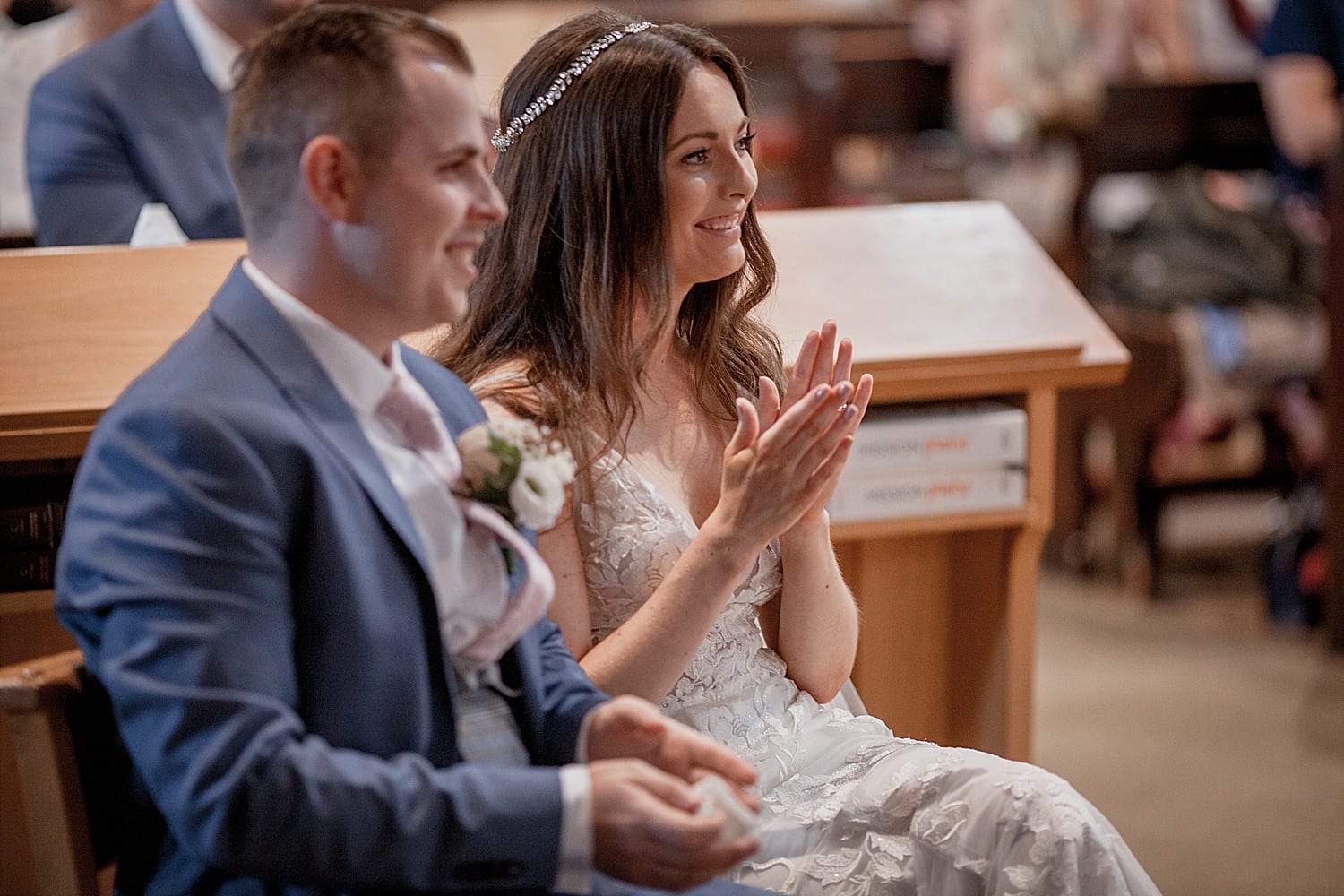 Bride and groom applaude at church wedding