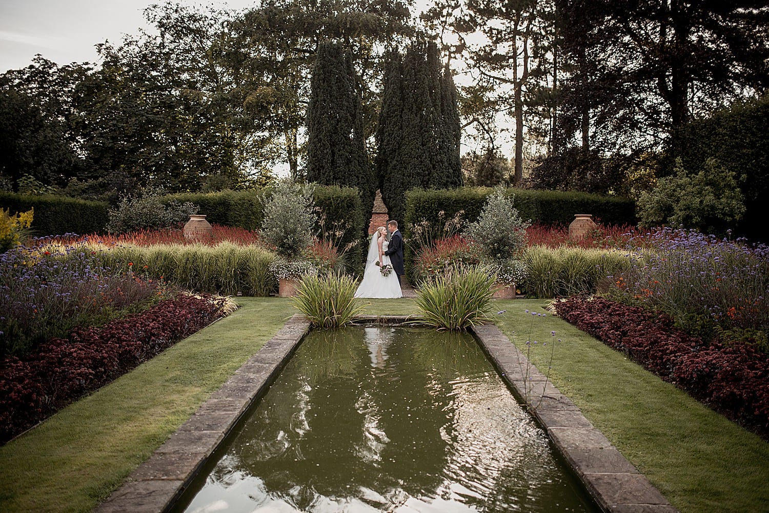 bride and groom near the pond in abbeywood estate gardens