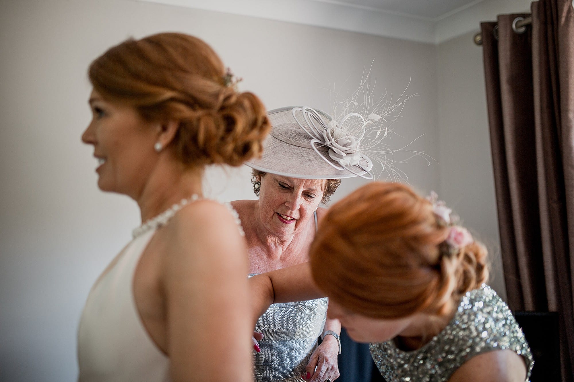 brides mum helps with the dress