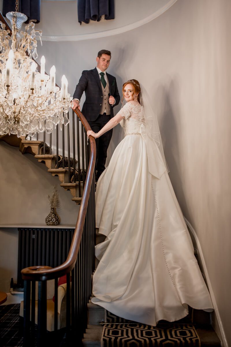 bride and groom on staircase at rossett hall