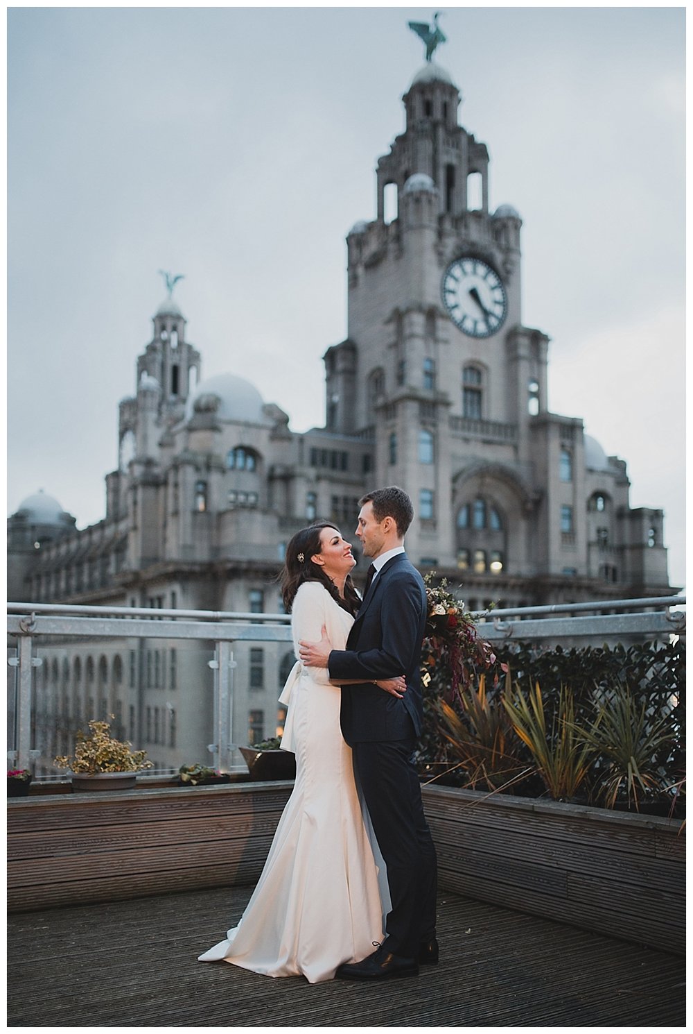  Bride and groom on the roof terrace at Oh Me Oh My Liverpool. The Liver building and Liver birds in the background. 